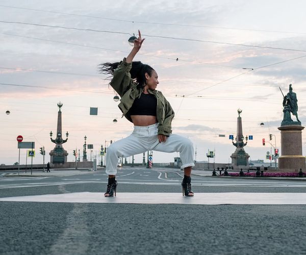 Person performing a fluid, energetic movement in a bright, open space.